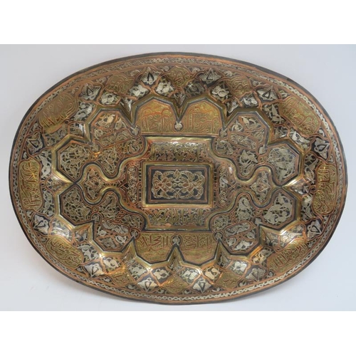 220 - A large Middle Eastern damascened metalwork tray. Profusely decorated to the front with a damascene ... 