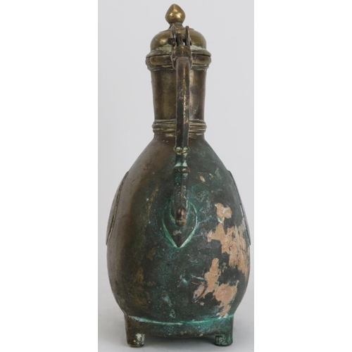 30 - A Mughal Indian engraved brass ewer, 18th century. Of bulbous form with a hinged cover and supported... 