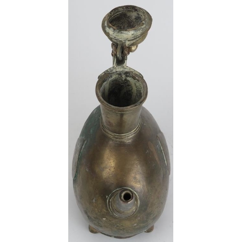 30 - A Mughal Indian engraved brass ewer, 18th century. Of bulbous form with a hinged cover and supported... 