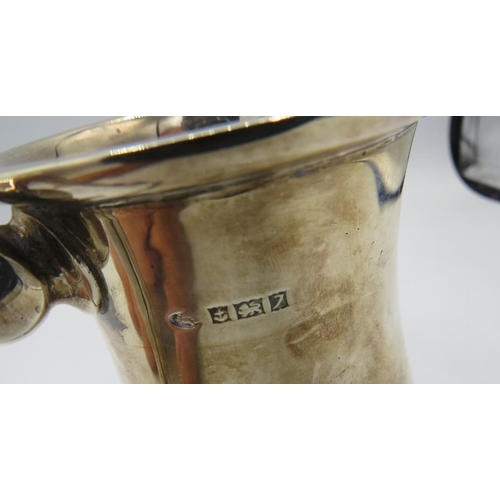 341 - A heavy silver pint tankard with double scroll handle & pedestal foot, Birmingham 1958, monogrammed.... 