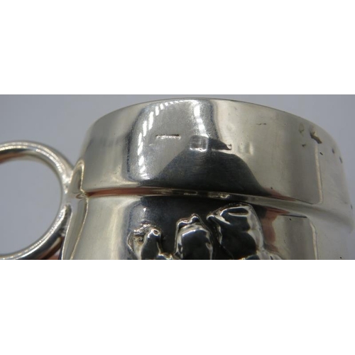 342 - A silver christening mug decorated with dancing figures & a musician. Hallmarks very worn. Approx we... 