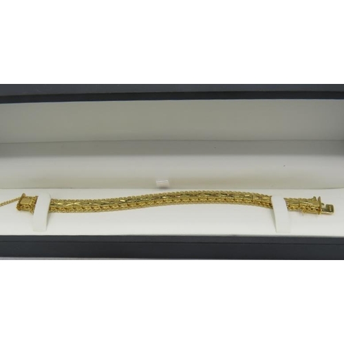 431 - A heavy yellow gold plated jointed bracelet with X design and safety chain, boxed. Approx weight 25.... 