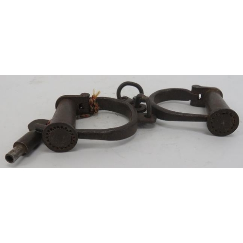 47 - A pair of cast iron handcuff shackles, probably 19th century. Condition report: Some wear with age.