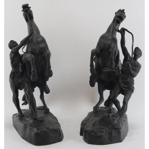 64 - A pair of bronzed metal male figures with rearing marly horses. Modelled after works by the French s... 