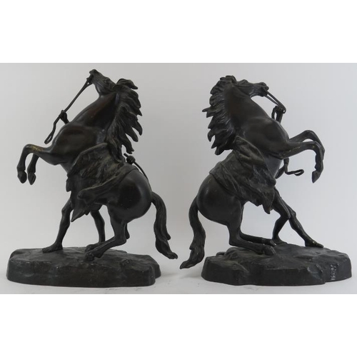 64 - A pair of bronzed metal male figures with rearing marly horses. Modelled after works by the French s... 