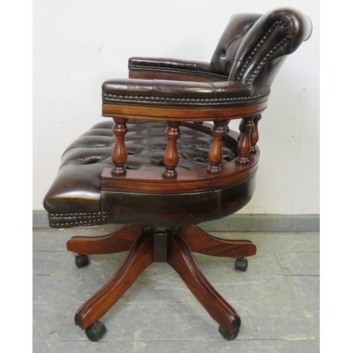 705 - An antique style mahogany captain’s height adjustable swivel desk chair, upholstered in buttoned gre... 