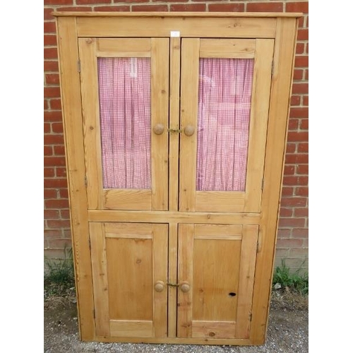 716 - An antique stripped pine pantry cupboard, the top section with glazed doors opening onto two fitted ... 