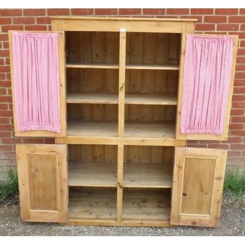 716 - An antique stripped pine pantry cupboard, the top section with glazed doors opening onto two fitted ... 