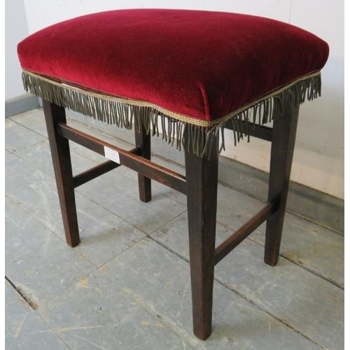 718 - A King George V mahogany Coronation stool, upholstered in claret velvet on tapering square supports ... 