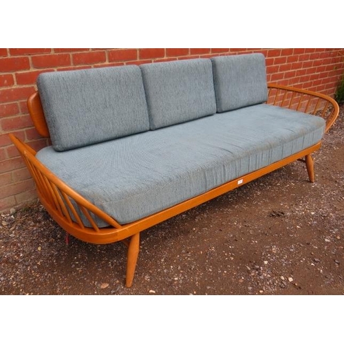 720 - A mid-century blonde elm and beech Windsor daybed by Ercol with loose cushions reupholstered in teal... 