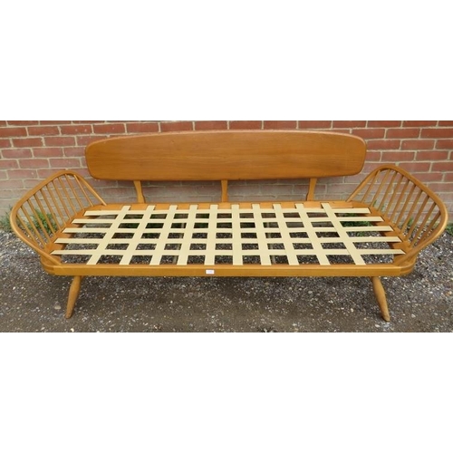 720 - A mid-century blonde elm and beech Windsor daybed by Ercol with loose cushions reupholstered in teal... 