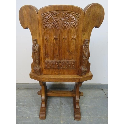 723 - A medium oak hall chair in the Gothic taste, with relief carving to the reverse depicting an ecclesi... 