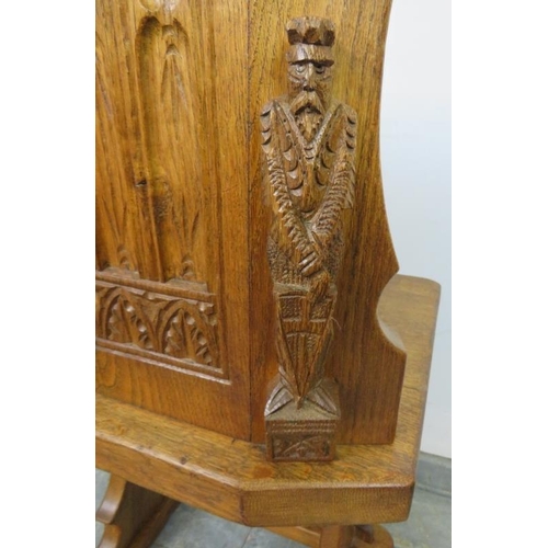 723 - A medium oak hall chair in the Gothic taste, with relief carving to the reverse depicting an ecclesi... 