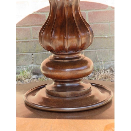 725 - An early Victorian mahogany circular tilt-top dining table, the top with sectioned veneer, on a bulb... 