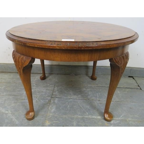 729 - A 1920s figured walnut low circular coffee table, on acanthus carved cabriole supports with pad feet... 