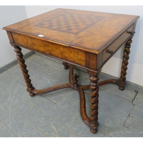 730 - A reproduction burr walnut games table by Theodore Alexander, the sliding central section with inlai... 