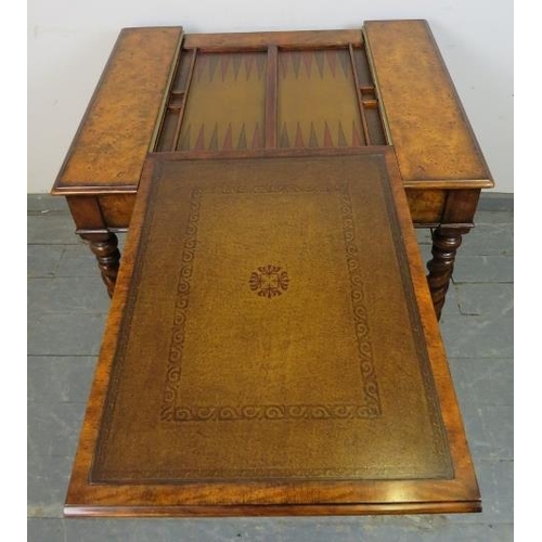 730 - A reproduction burr walnut games table by Theodore Alexander, the sliding central section with inlai... 