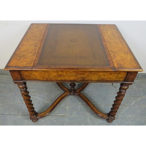 730 - A reproduction burr walnut games table by Theodore Alexander, the sliding central section with inlai... 