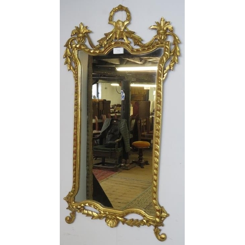 752 - A giltwood wall mirror in the Neo-Classical taste, the acanthus carved cornice with urn finials, the... 