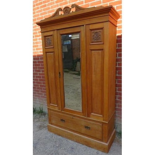 755 - An Edwardian lightwood double wardrobe with scrolled pediment, the front with carved and fielded pan... 