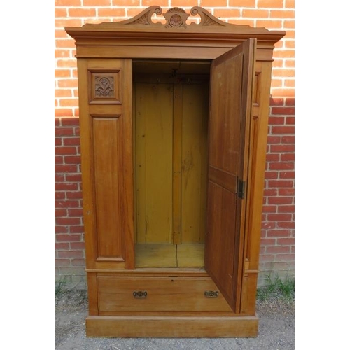 755 - An Edwardian lightwood double wardrobe with scrolled pediment, the front with carved and fielded pan... 