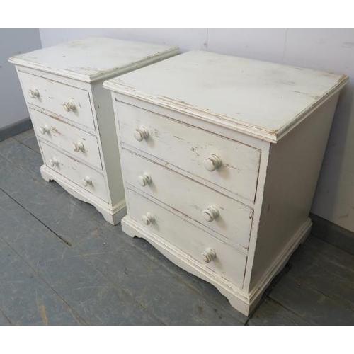 759 - A pair of pine bedside chests, each housing three long drawers with turned wooden handles, painted d... 