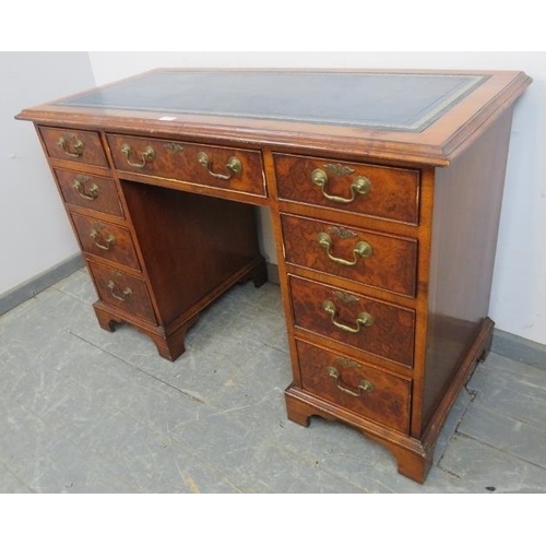 765 - An Edwardian burr walnut pedestal desk, the inset blue leather writing surface with gilt tooled and ... 