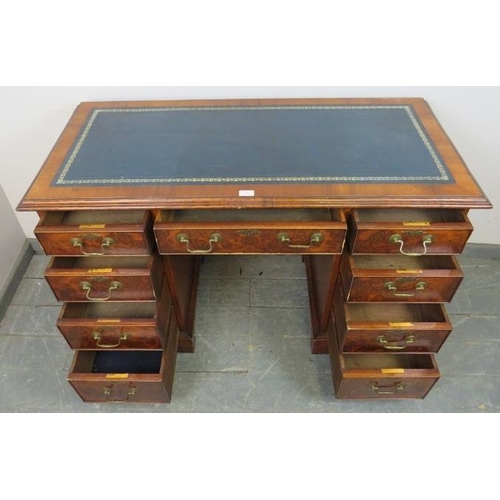 765 - An Edwardian burr walnut pedestal desk, the inset blue leather writing surface with gilt tooled and ... 