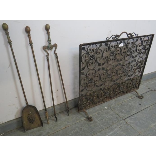 788 - A wrought iron and mesh freestanding fire screen with scrolled and applied rosette detail, on scroll... 