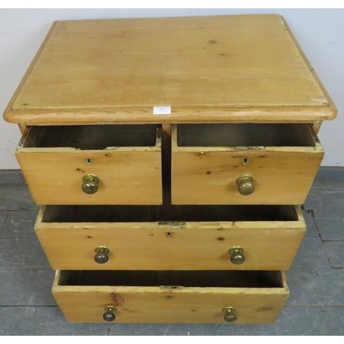 805 - A small antique pine chest of two short over two long drawers with brass knob handles, on block feet... 