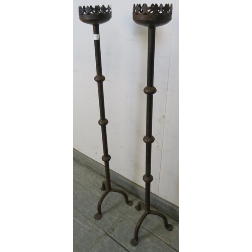 818 - A pair of vintage wrought iron floor-standing candlesticks in the Gothic taste, on tripod bases with... 