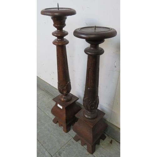 819 - A near pair of hardwood hand carved table top candlesticks with acanthus leaf detail, on bulbous pli... 