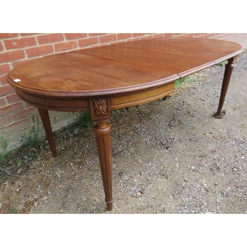 820 - A turn of the century oak oval draw leaf dining table, with two additional leaves, on tapering reede... 