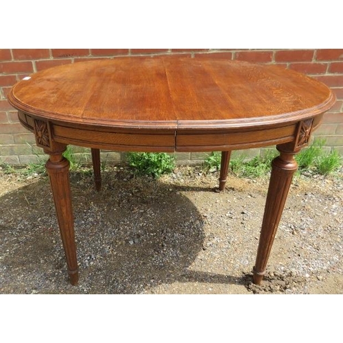 820 - A turn of the century oak oval draw leaf dining table, with two additional leaves, on tapering reede... 