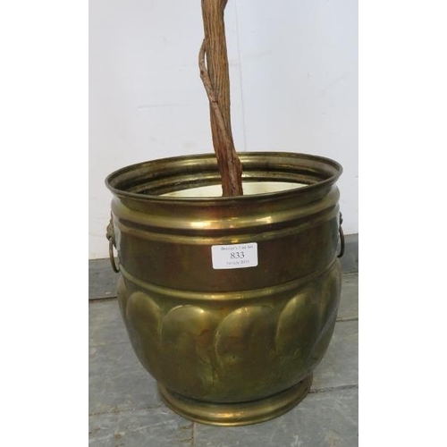 833 - An artificial bay tree in an Arts & Crafts brass planter with cast lion mask handles. 
H185cm (appro... 