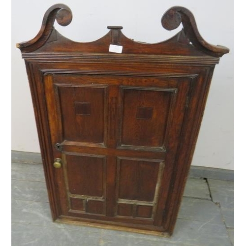 845 - A 19th century oak wall hanging corner cupboard, with scrolled pediment and inlaid panelled door, ho... 