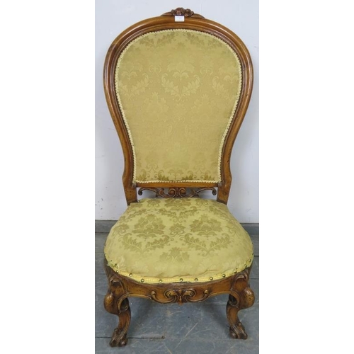 857 - A Victorian walnut spoonback nursing chair, upholstered in gold damask material, on scrolled support... 