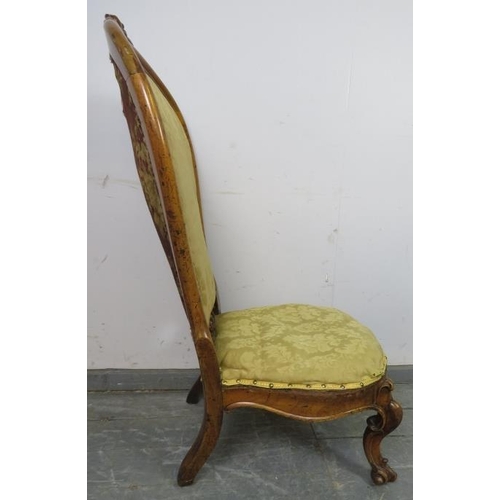 857 - A Victorian walnut spoonback nursing chair, upholstered in gold damask material, on scrolled support... 