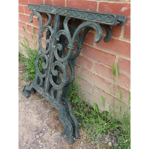 899 - A pair of cast iron table supports painted green, with scrolled and pierced decoration. 
H66cm W68cm... 