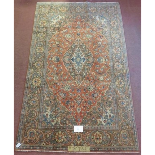 916 - A signed Persian Kashan carpet with central motif on burnt amber field. In good condition. 225cm x 1... 