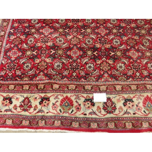 918 - A fine mid 20th century Persian carpet central block pattern on red ground with flowered cream borde... 