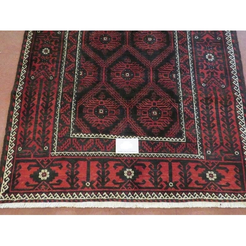 919 - A North East Persian meshed Belouch rug deep burgundy high lighted with black and white. In good con... 