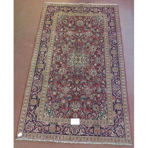 925 - A Persian Ardkan carpet central heavy floral patterns on red ground with wide blue borders. In good ... 