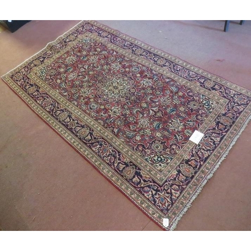 925 - A Persian Ardkan carpet central heavy floral patterns on red ground with wide blue borders. In good ... 