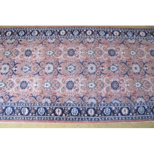 926 - A late 20th century Persian runner, central repeat pattern on dusky pink ground and blue borders. 27... 