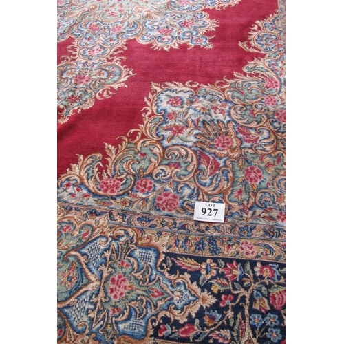 927 - A mid 20th century Persian carpet with a large central floral motif on a red ground with deep 52cm b... 