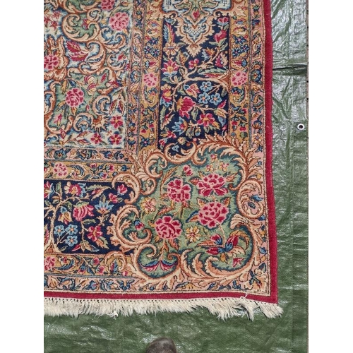 927 - A mid 20th century Persian carpet with a large central floral motif on a red ground with deep 52cm b... 