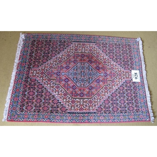 928 - A small Persian rug, graduated central motif on blue ground with repeat pattern. 75cm x 110cm.