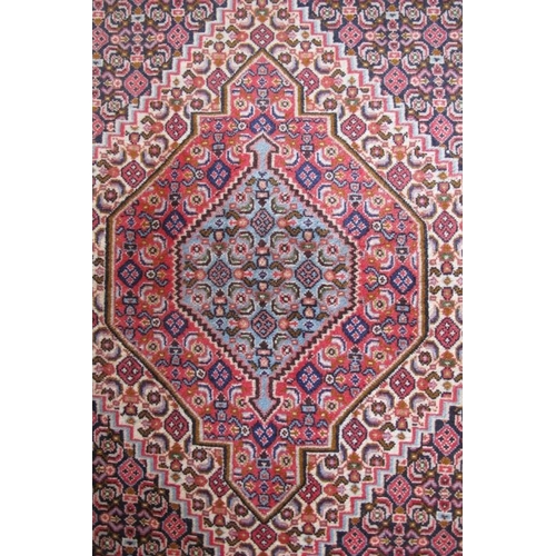 928 - A small Persian rug, graduated central motif on blue ground with repeat pattern. 75cm x 110cm.