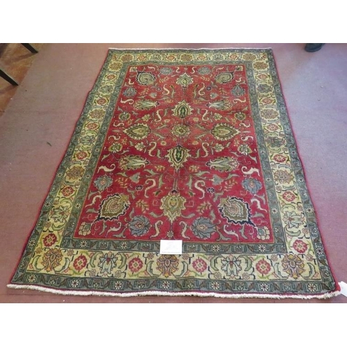 931 - A North West Persian Tabriz rug, a central area depicting flowers on red ground, surrounded by a tri... 